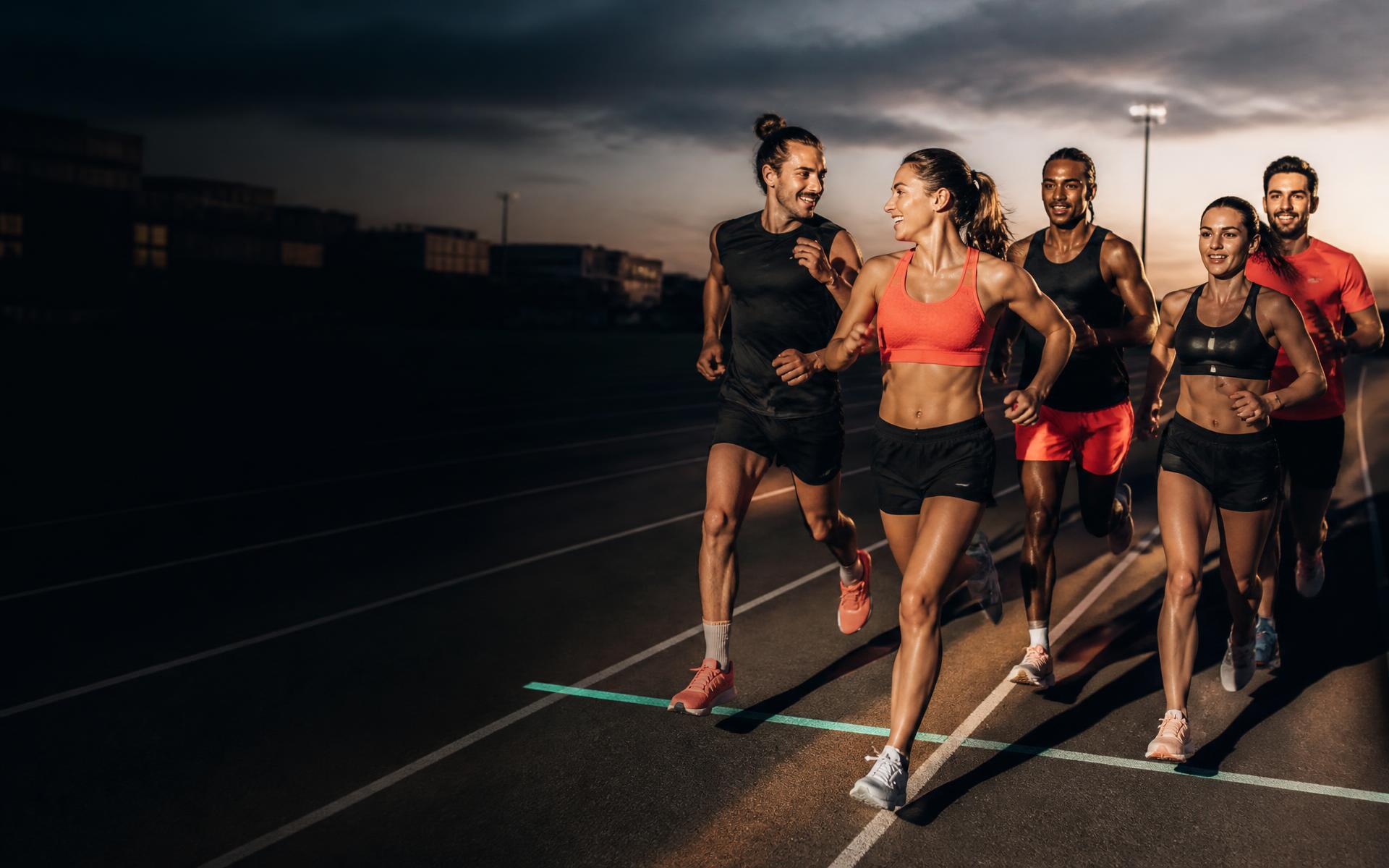Cinco amigos compitiendo juntos en una pista de atletismo